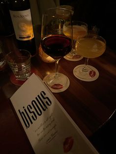 several glasses of wine are sitting on a table next to a paper with the word discous written on it