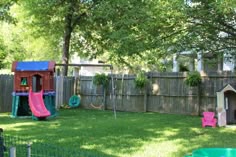 a backyard with a play set, slide and dog house