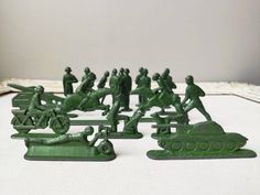 some green army figurines sitting on top of a table