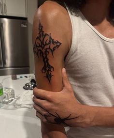 a man with a cross tattoo on his arm