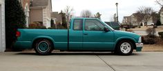 a blue pick up truck parked in front of a house