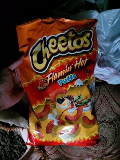 a bag of cheetos sitting on top of a bed