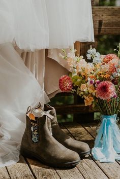 the bride and groom's wedding shoes are sitting next to each other with flowers in them