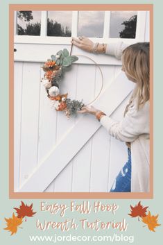 a woman is making a wreath on the side of a white door with text overlay that reads easy fall hoop wreath