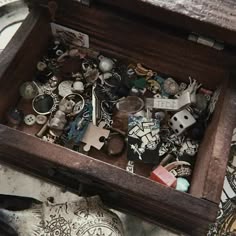 a wooden box filled with lots of different types of buttons and jewelry on top of a table