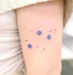 small blue flowers on the back of a woman's right arm and left leg