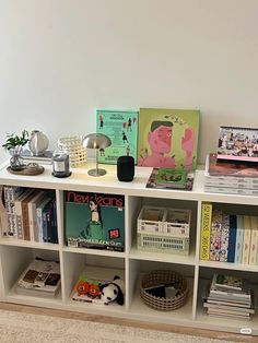 a book shelf filled with books next to a white wall