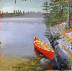 an orange canoe sitting on the shore of a lake