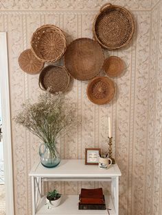a white table with baskets on the wall above it