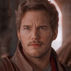 a close up of a person wearing a leather jacket and looking at the camera with a serious look on his face