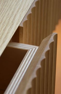 an open drawer in a wooden cabinet with woodgrains on the bottom and sides