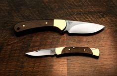 two knives sitting side by side on top of a wooden table next to each other