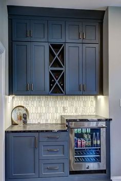 a kitchen with blue cabinets and an ice chest in the corner, along with a wine cooler