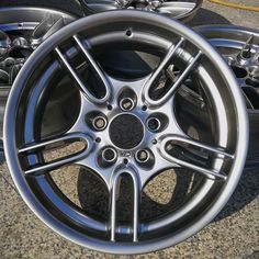 some shiny silver rims are sitting on the ground