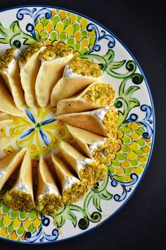 a plate with some food on it and flowers around the edges, including pita bread