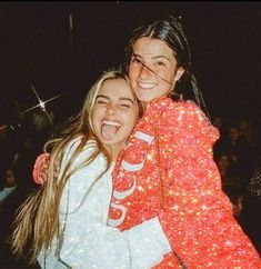 two girls hugging each other in front of a crowd