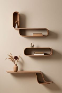 two shelves with books and vases on them against a wall, one shelf is empty