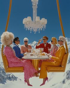 a group of people sitting at a table in the snow