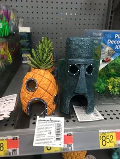 two pineapples and a pineapple mask are on the shelf in a store