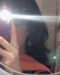 a woman taking a selfie in front of a mirror with her cell phone up to her face