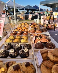 many different types of cookies and pastries on display at an open air market stall
