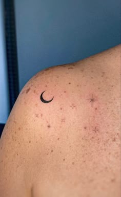 the back of a man's shoulder with stars and a crescent tattoo