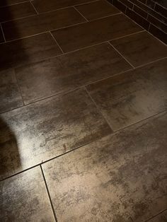 a bathroom floor that has been cleaned and is brown in color, with the light shining on it