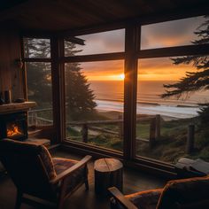 a living room filled with furniture and a fire place next to a window overlooking the ocean