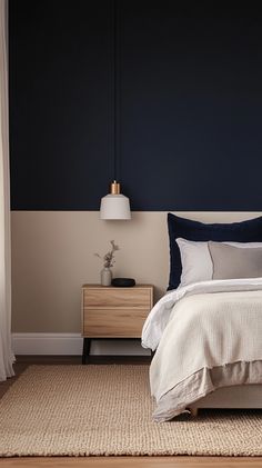 a bedroom with a bed, nightstands and lamp on the side table in front of it