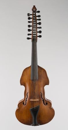 an old violin hanging from the ceiling with strings attached to it's back end