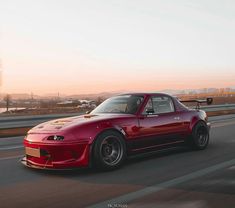 a red sports car driving down the road