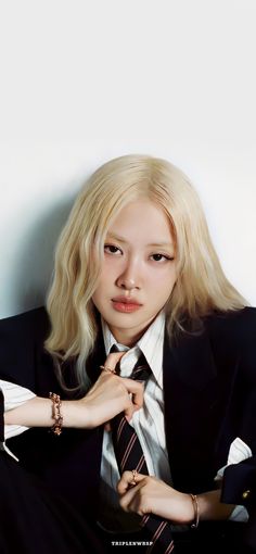 a woman with blonde hair wearing a suit and tie