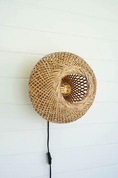 a lamp that is on the wall next to a light fixture with a cord in front of it