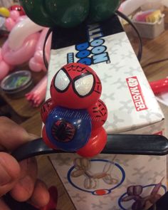 a person is holding a toy in front of a box with balloons and other toys