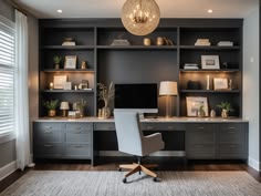 a home office with built - in shelving and lighting