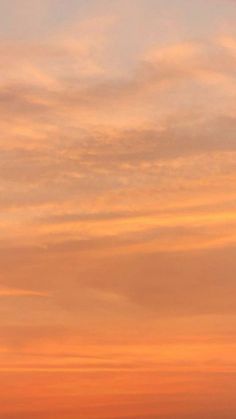 an airplane is flying in the sky at sunset or dawn with orange and pink clouds