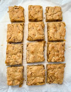 eight squares of brownies sitting on top of a piece of parchment paper next to each other