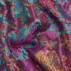 purple and blue paisley print fabric with metallic foil on the edges, close up view