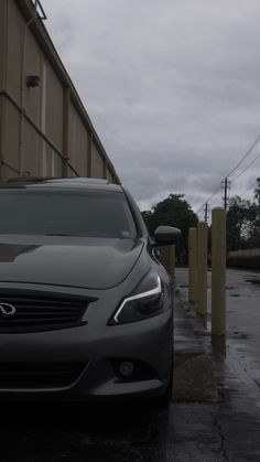 a car parked next to a parking meter on a wet street in front of a building