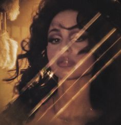 a close up of a person with long hair and an open mouth, holding a cell phone to her ear