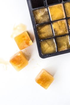 some ice cubes sitting on top of a white table next to an orange slice