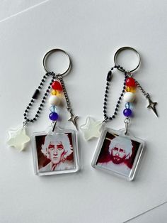 two key chains with pictures and beads hanging from them