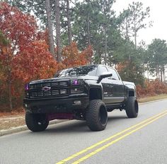 a large black truck is driving down the road