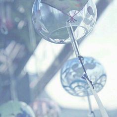 a close up of a wind chime with glass balls in the background