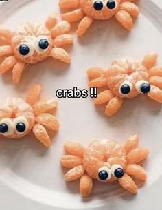 four orange crabs on a white plate with black eyes and one has two large googly eyes