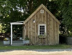 a small wooden shed sitting next to a tree
