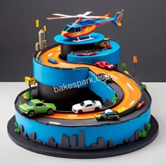 a cake with cars, trucks and helicopter on it