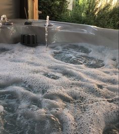 an outdoor hot tub with water running down it