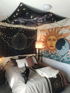 a cat is standing on top of a bed in a room with lights and tapestry