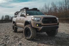 a tan truck is parked in the dirt